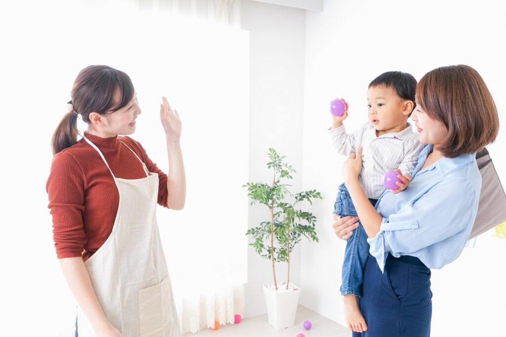 母子と手を振る保育士