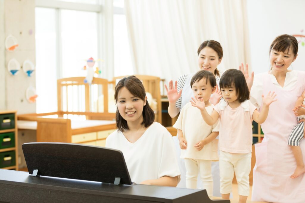 ピアノを弾く保育士と子どもたち