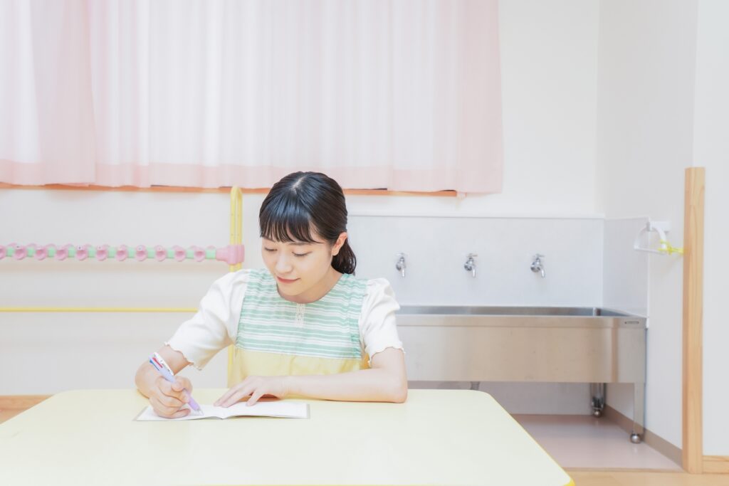 ノートに字を書く女性