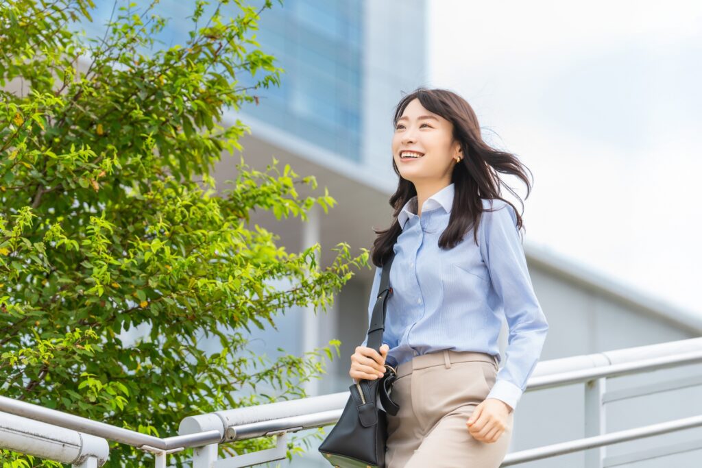 前向きな気持ちで街中を歩くオフィス街の女性