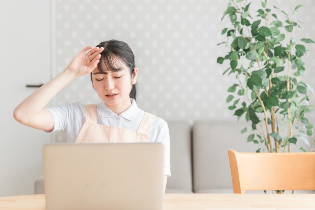 PCで作業して疲れている保育士