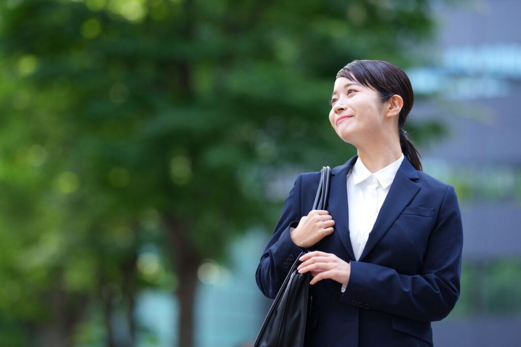 再就職活動に向けてリクルートスーツを着用し、前向きな表情を浮かべる女性