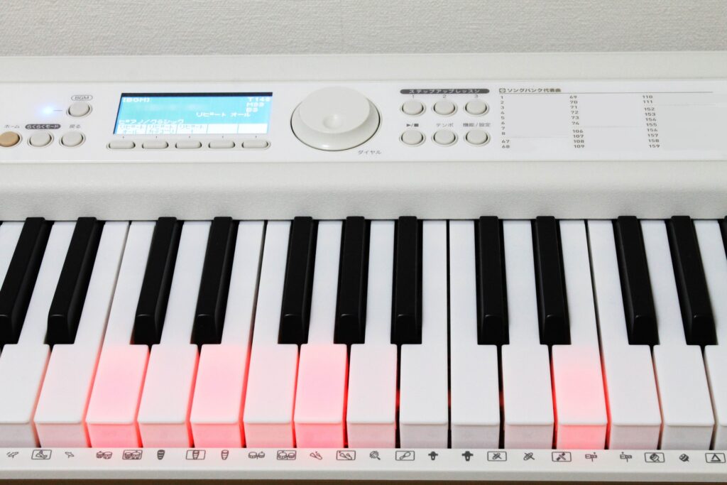 鍵盤が光る白い電子ピアノ
