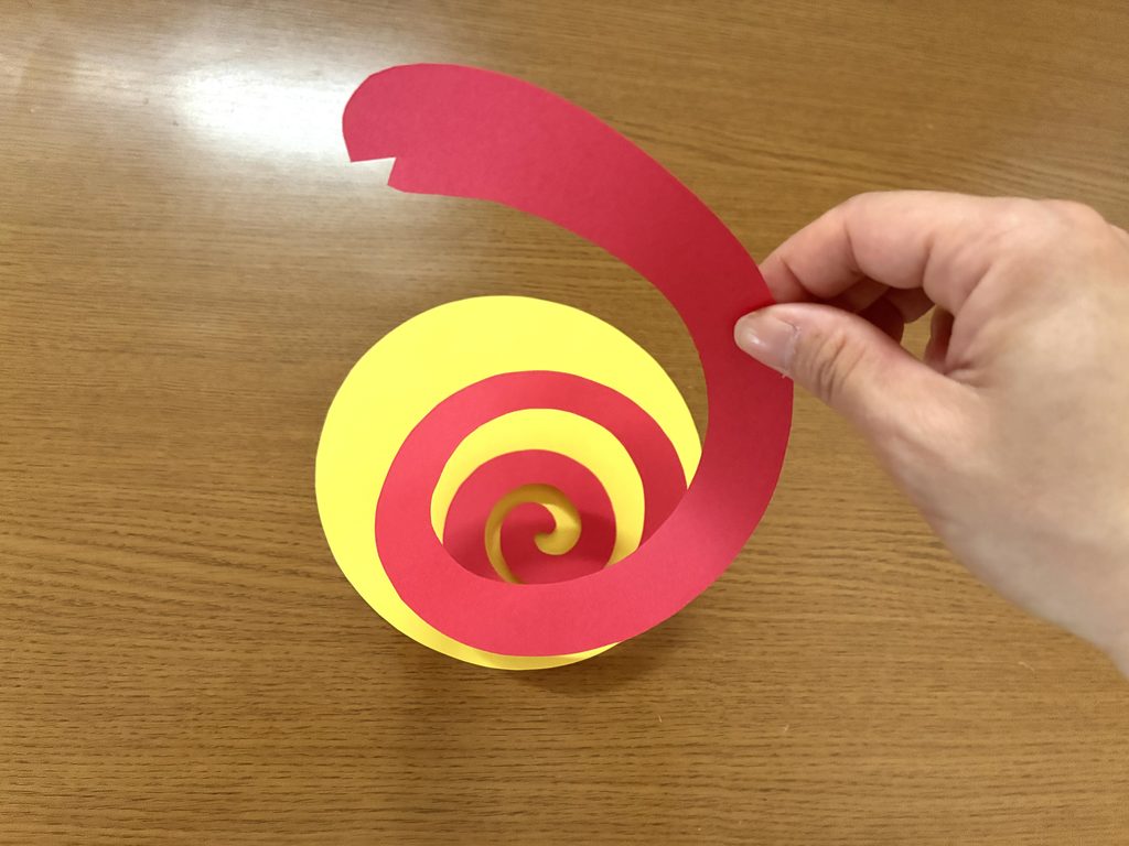 色画用紙で黄色の丸と赤いヘビを切ったところ